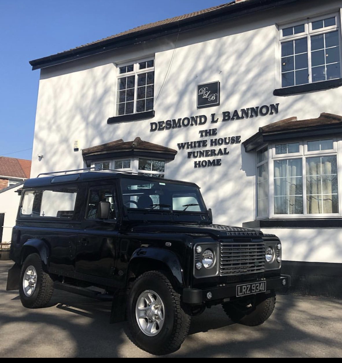 A black Land Rover Defender hearse in front of The White House